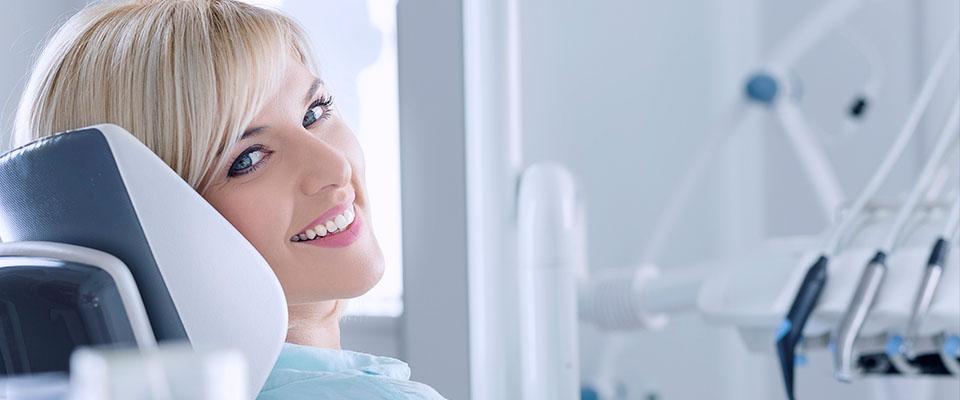 Uśmiechnięta kobieta na fotelu dentystycznym